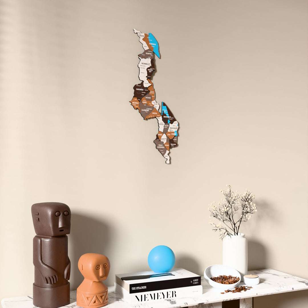 Soil Malawi wooden wall map on a beige wall above a console with figurines