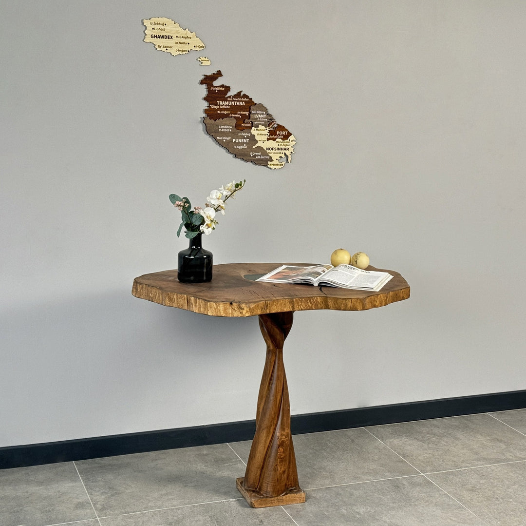 Malta wooden wall map above a round-edged wood table with a vase, lower angle