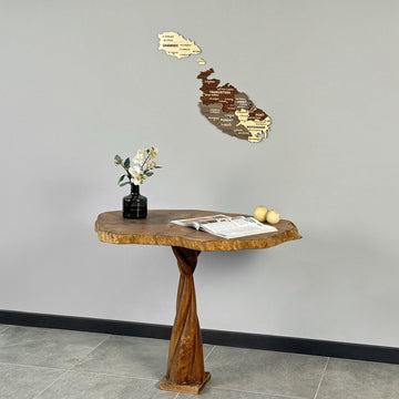 Wooden Malta map on a gray wall above a twisted-base table, view from the right