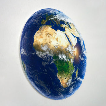 UV-printed metal wall art of Earth showing Africa and the Middle East from space, tilted oval view