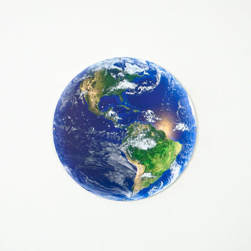Metal Earth wall art showing North and South America on a white wall, straight-on view