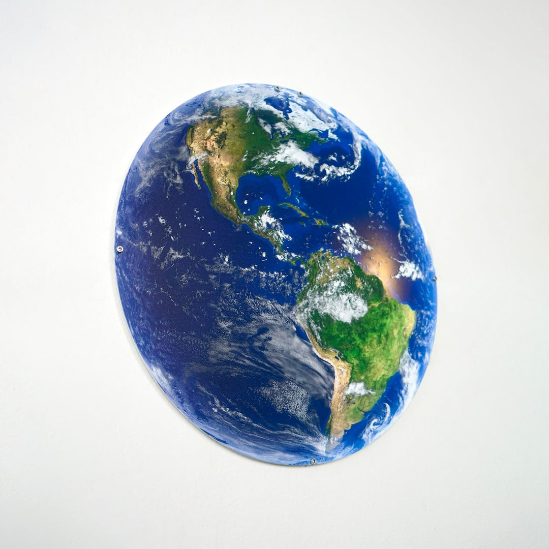Metal Earth wall art with the Americas facing right on a light wall, angled view