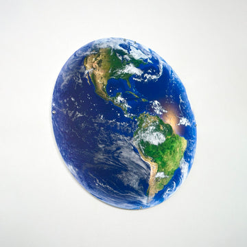 Metal Earth wall art with the Americas facing right on a light wall, angled view