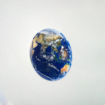 Metal Earth wall art showing Asia, with Australia at the bottom, on a gray wall, angled view