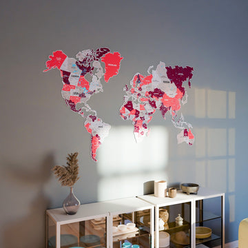 Crimson metal world map above a white glass-door cabinet on a gray wall