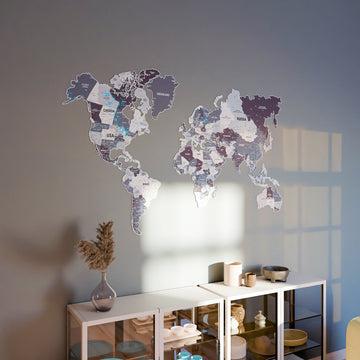 Nimbus metal world map on a blue-gray wall above a white glass cabinet with decor