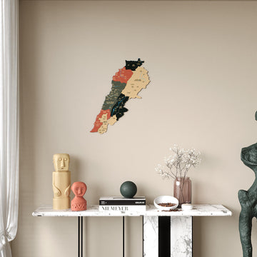 Sage Lebanon wooden wall map in sage green, terracotta and charcoal, above a console with a cream figurine