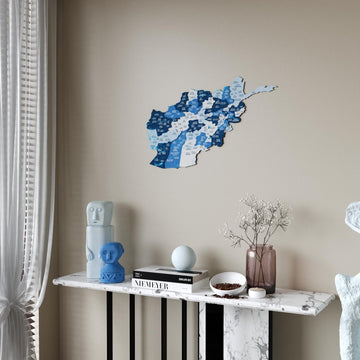Navy blue Afghanistan wooden wall map next to a sheer curtain above a white marble console