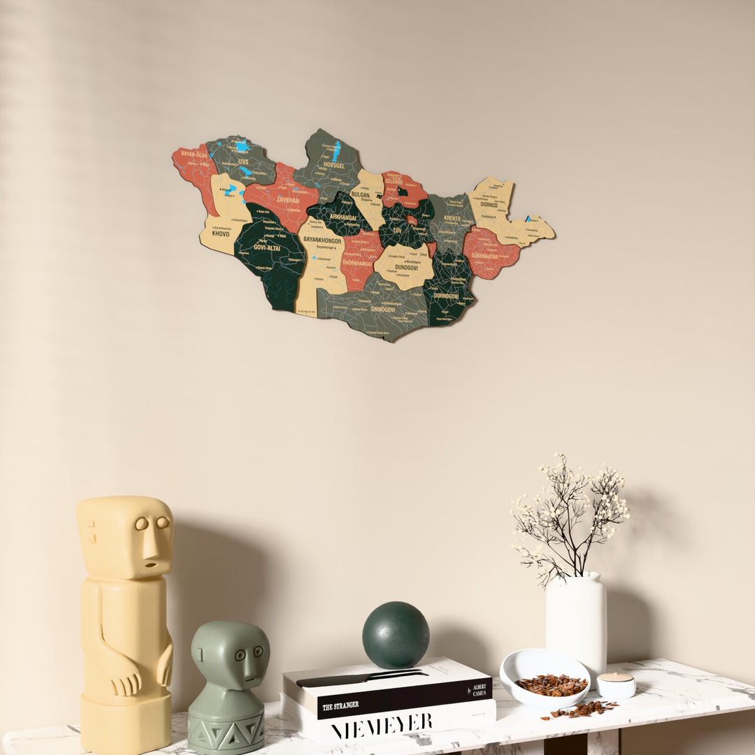 Sage Mongolia wooden wall map on a beige wall above a console with figurines