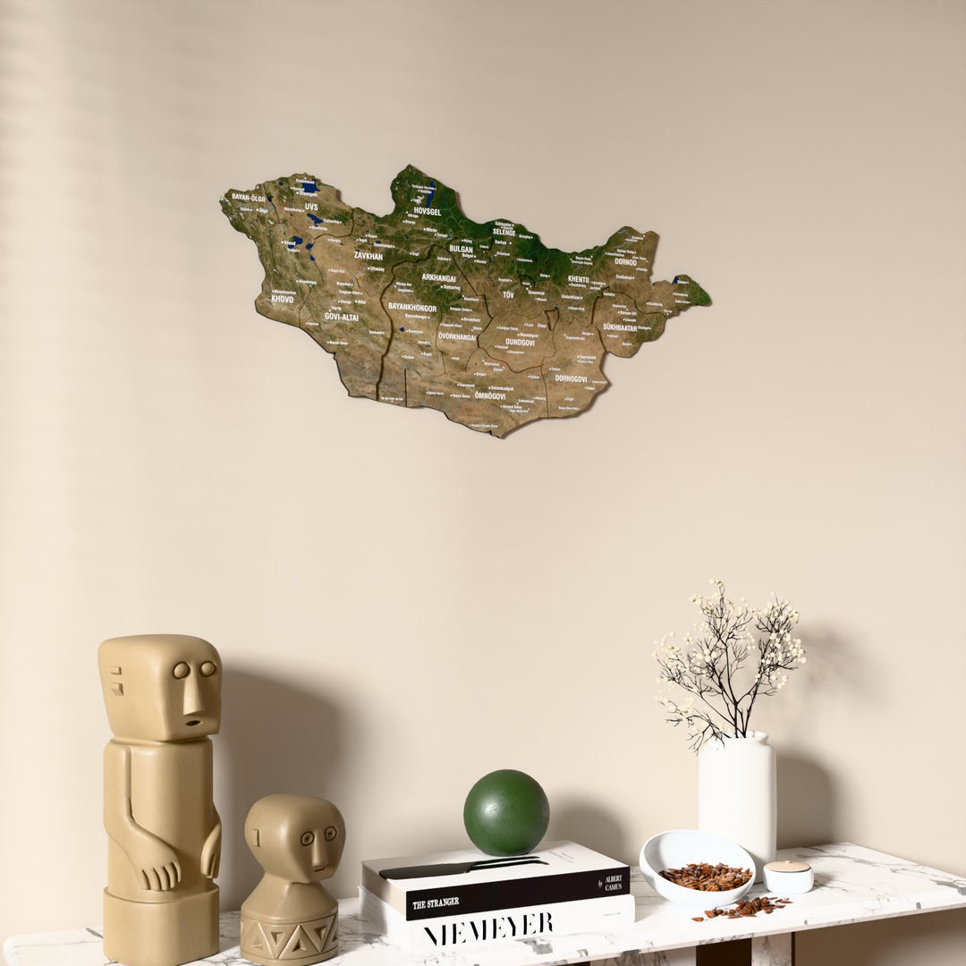 Satellite Mongolia wooden wall map on a beige wall above a console with figurines