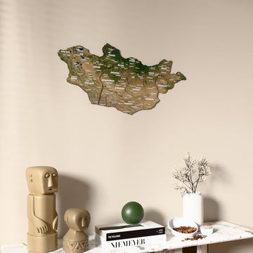 Satellite Mongolia wooden wall map on a beige wall above a console with figurines