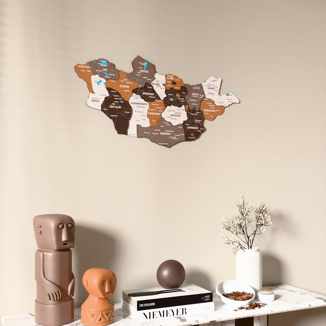 Soil Mongolia wooden wall map on a beige wall above a console with figurines