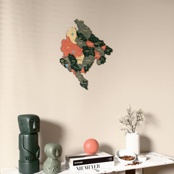Sage Montenegro wooden wall map on a beige wall above a console with figurines