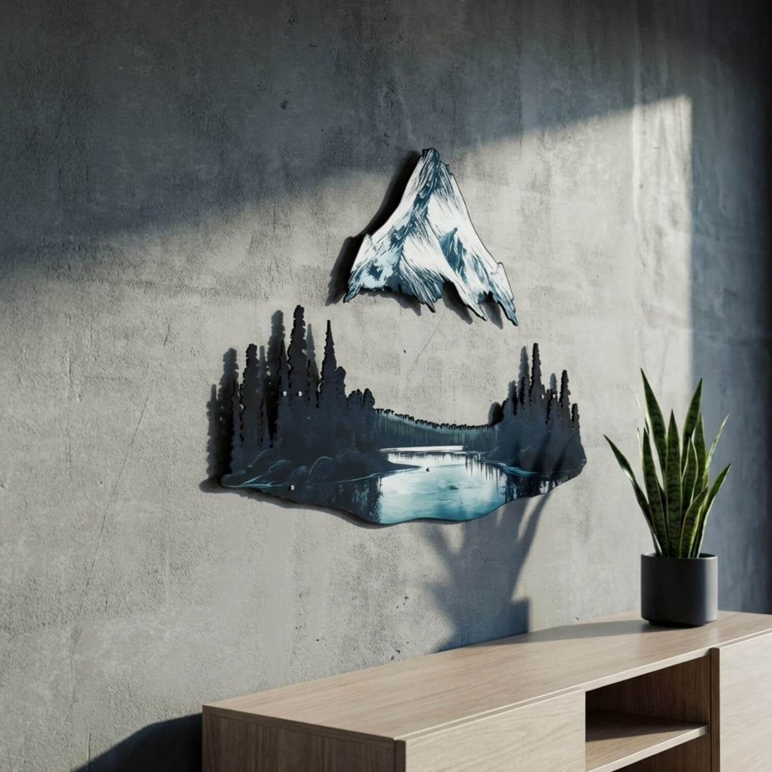 Mountain and lake metal wall decor at an angle, next to a snake plant