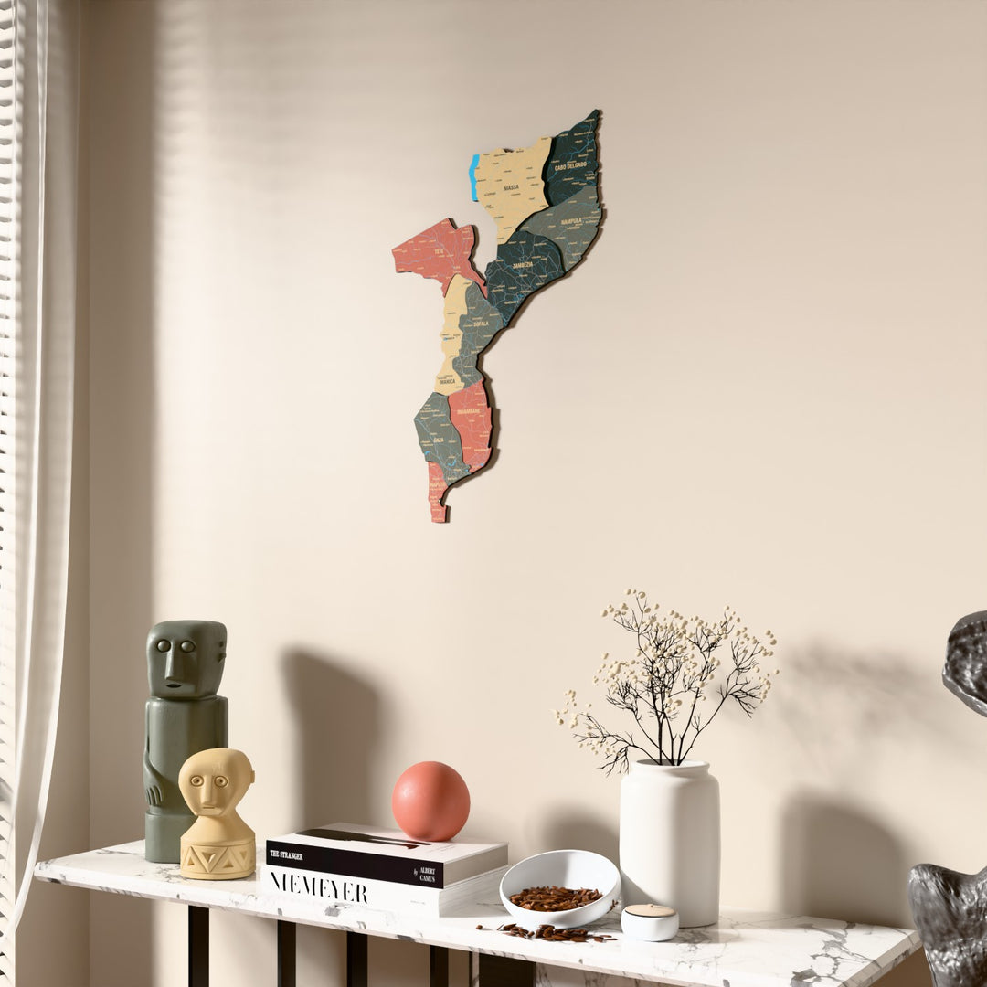 Sage Mozambique wooden wall map beside a sheer curtain, angled view