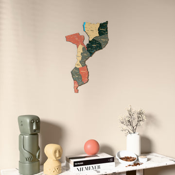 Sage Mozambique wooden wall map on a beige wall above a console with figurines