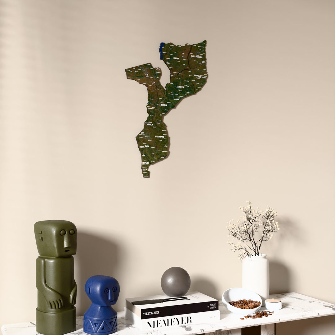 Satellite Mozambique wooden wall map on a beige wall above a console with figurines
