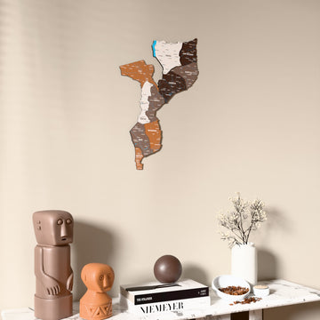 Soil Mozambique wooden wall map on a beige wall above a console with figurines
