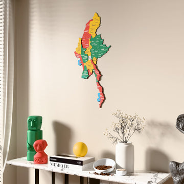 Flag colored Myanmar wooden wall map beside a sheer curtain, angled view