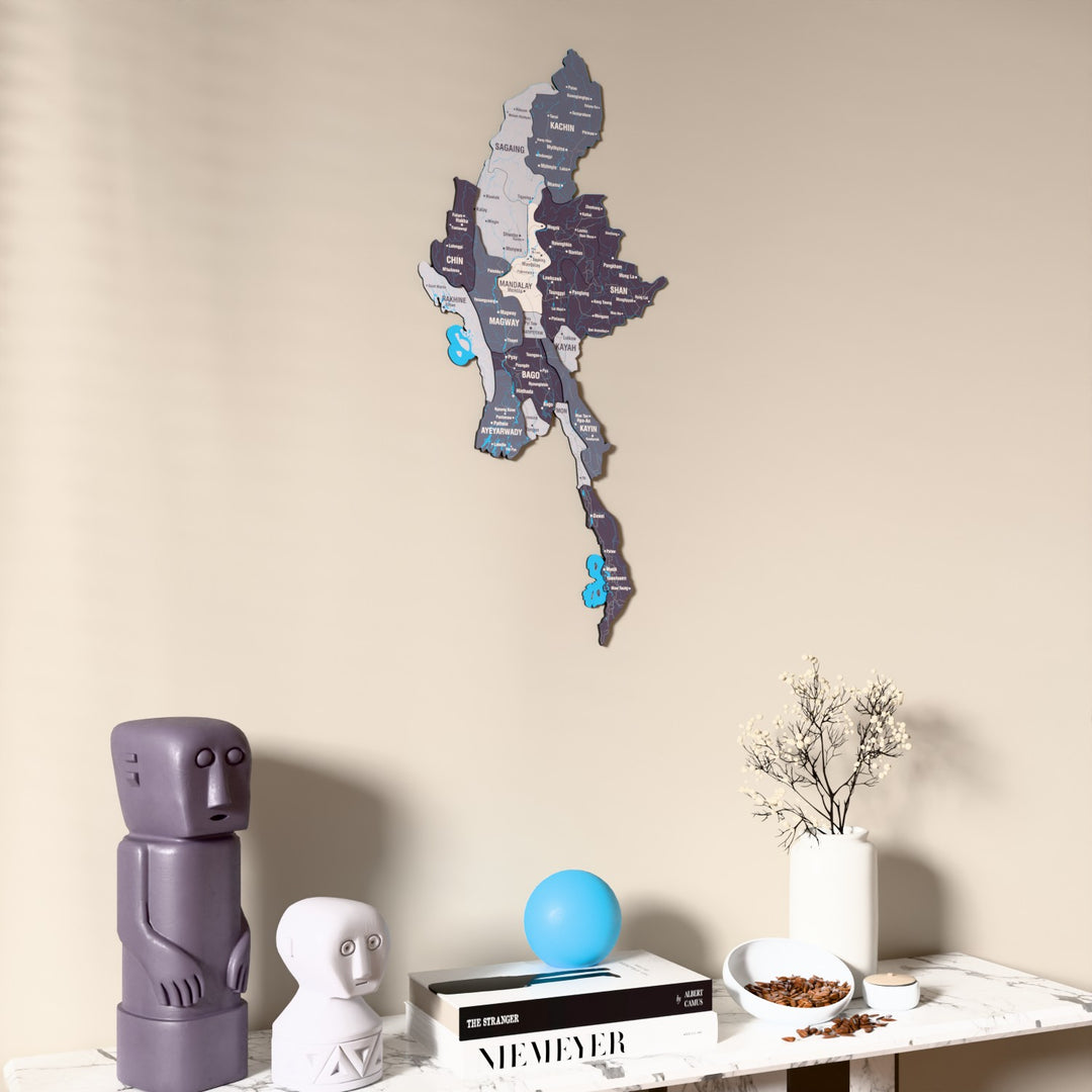 Nimbus Myanmar wooden wall map on a beige wall above a console with figurines