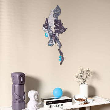 Nimbus Myanmar wooden wall map on a beige wall above a console with figurines