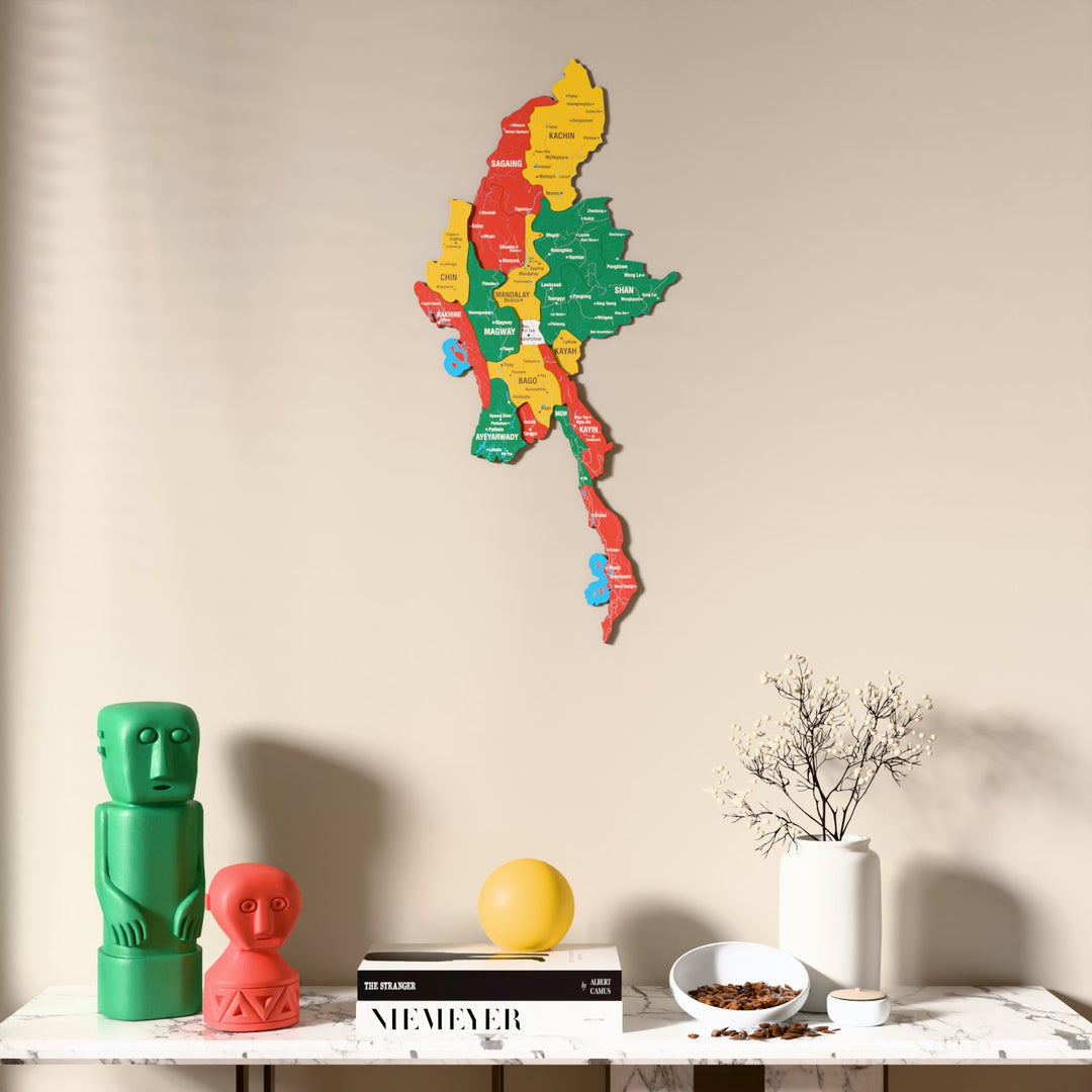 Flag colored Myanmar wooden wall map above a marble console, front view