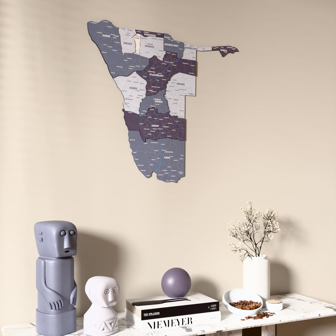 Nimbus Namibia wooden wall map on a beige wall above a console with figurines
