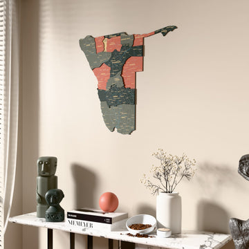 Sage Namibia wooden wall map beside a sheer curtain, angled view