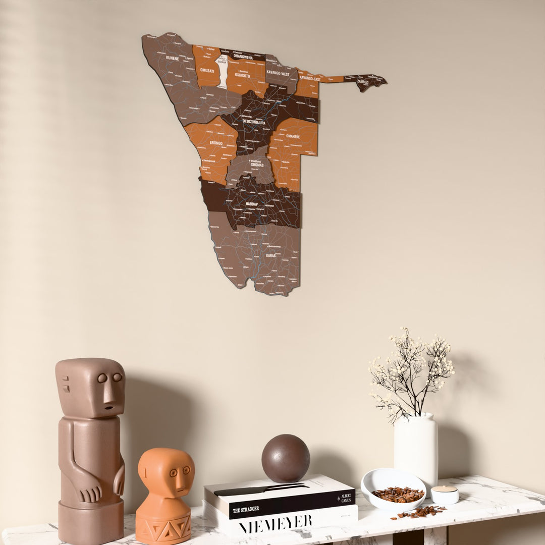 Soil Namibia wooden wall map on a beige wall above a console with figurines