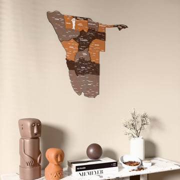 Soil Namibia wooden wall map on a beige wall above a console with figurines