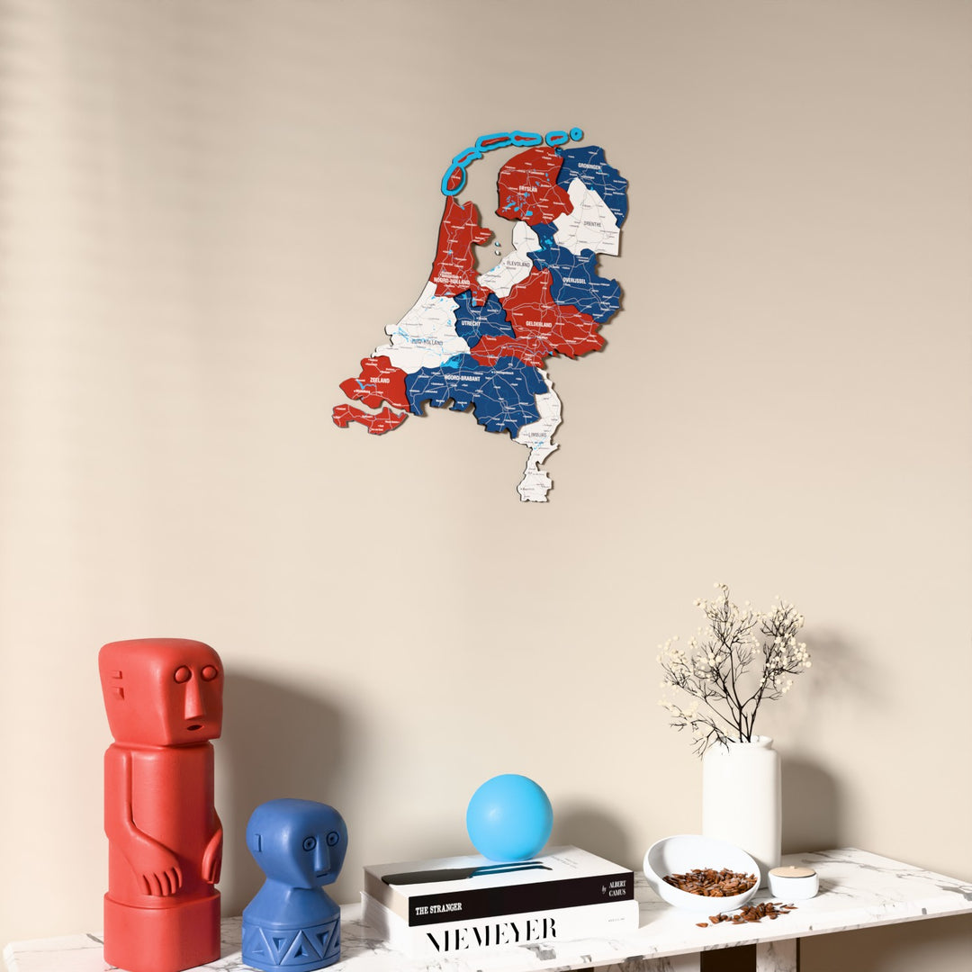 Flag colored Netherlands wooden wall map on a beige wall above a console with figurines