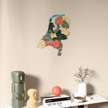 Sage Netherlands wooden wall map on a beige wall above a console with figurines