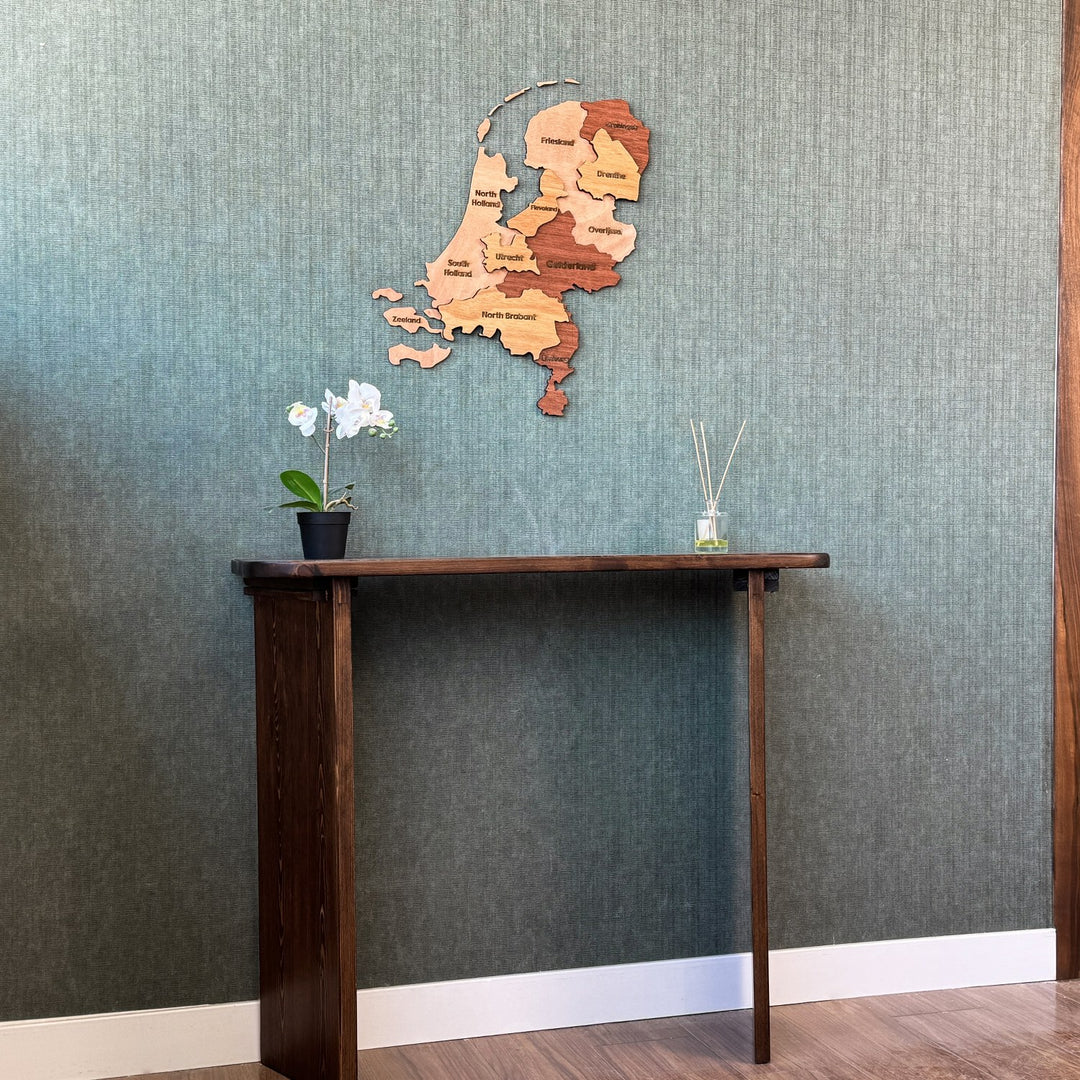 Wooden Netherlands map above a console table, wide view with a wood door frame at right