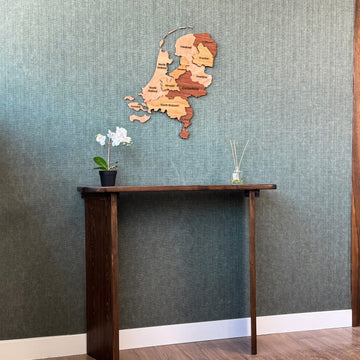 Wooden Netherlands map above a console table, wide view with a wood door frame at right