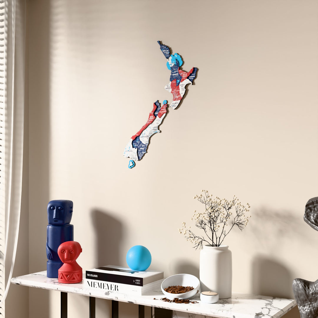 Flag colored New Zealand wooden wall map beside a sheer curtain, angled view