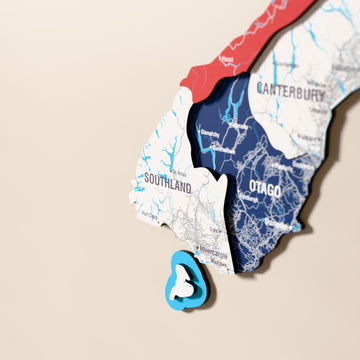 Close-up of the Flag colored New Zealand wooden wall map with layered regions and printed names