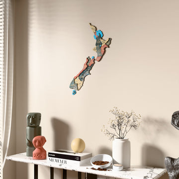 Sage New Zealand wooden wall map beside a sheer curtain, angled view