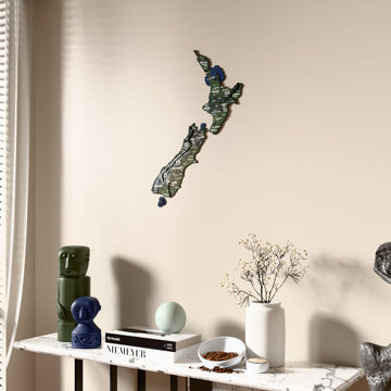 Satellite New Zealand wooden wall map beside a sheer curtain, angled view