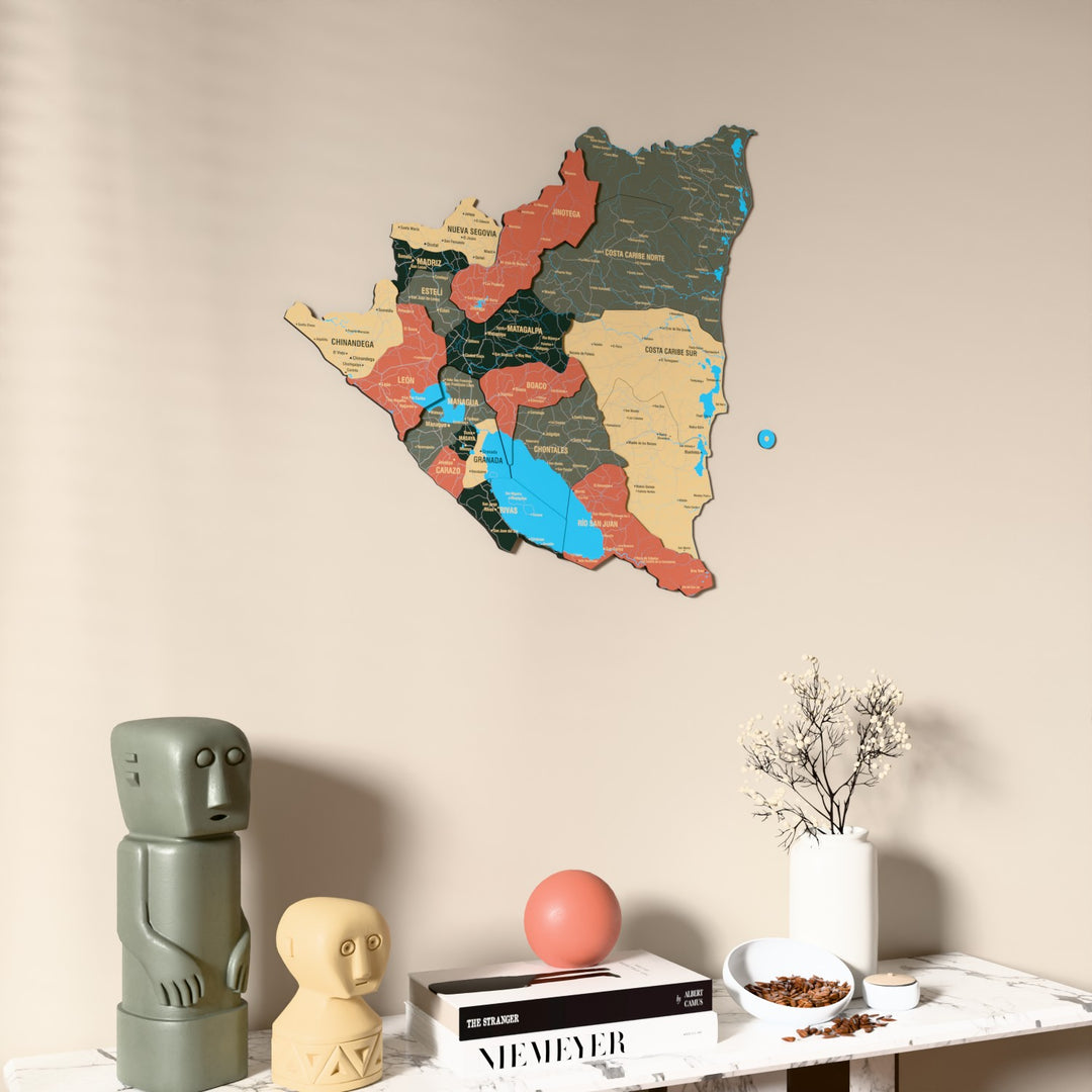 Sage Nicaragua wooden wall map on a beige wall above a console with figurines
