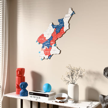 Flag colored North Korea wooden wall map beside a sheer curtain, angled view