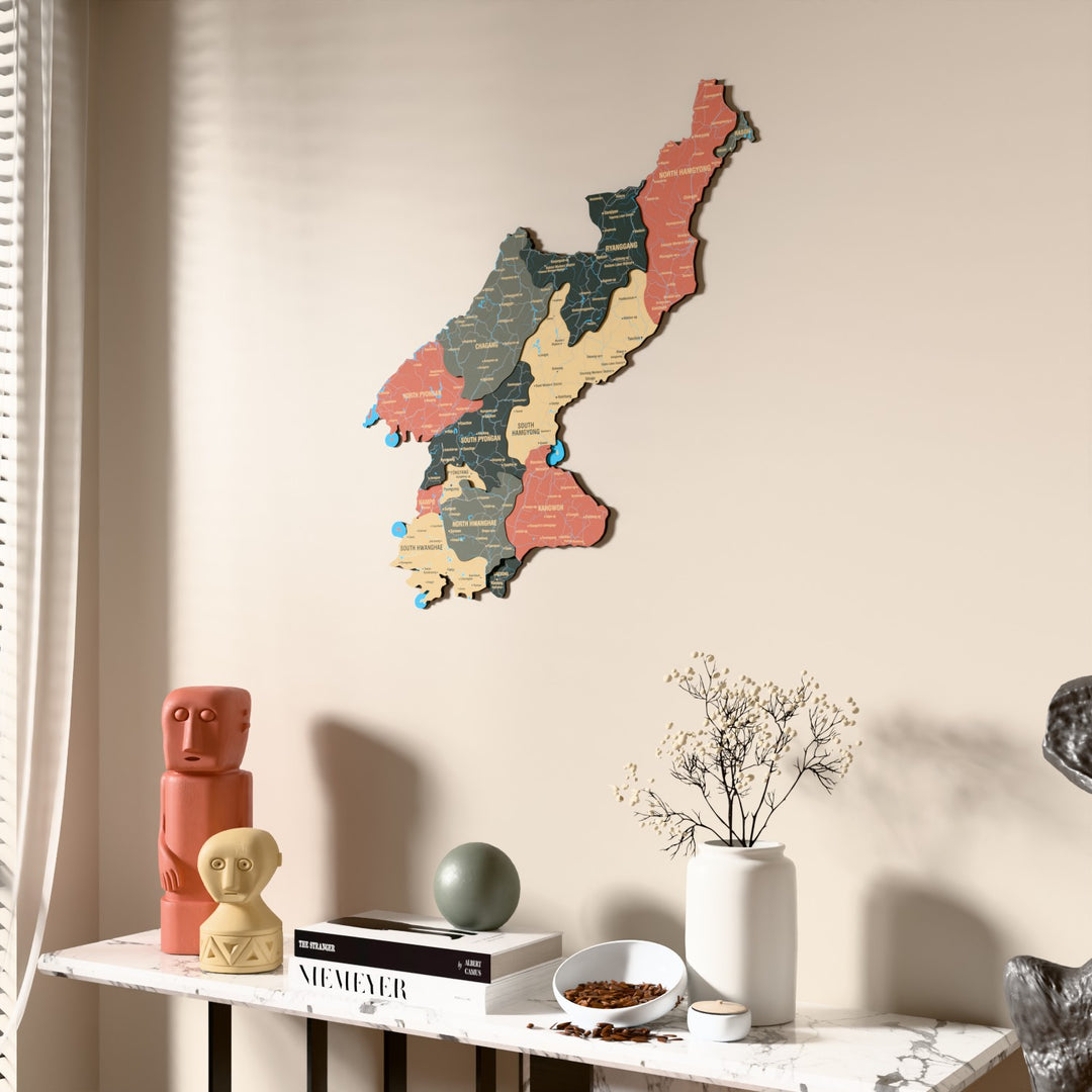 Sage North Korea wooden wall map beside a sheer curtain, angled view