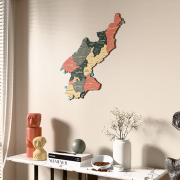 Sage North Korea wooden wall map beside a sheer curtain, angled view