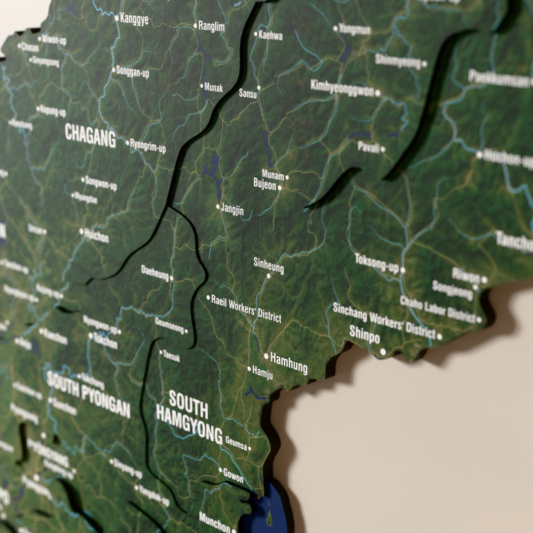 Close-up of the Satellite North Korea wooden wall map with layered regions and printed names