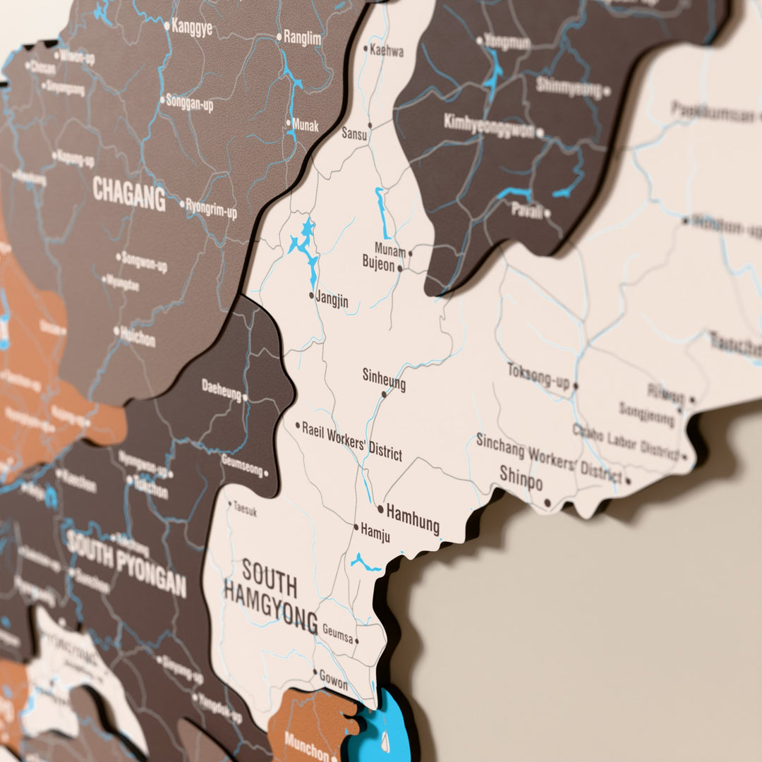 Close-up of the Soil North Korea wooden wall map with layered regions and printed names