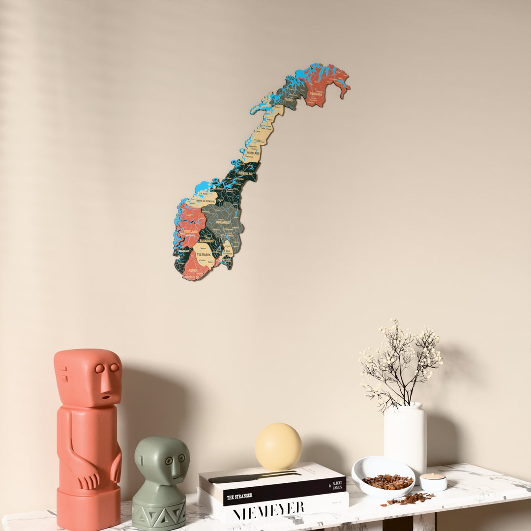 Sage Norway wooden wall map on a beige wall above a console with figurines
