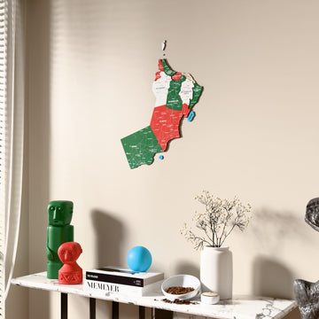 Flag colored Oman wooden wall map beside a sheer curtain, angled view