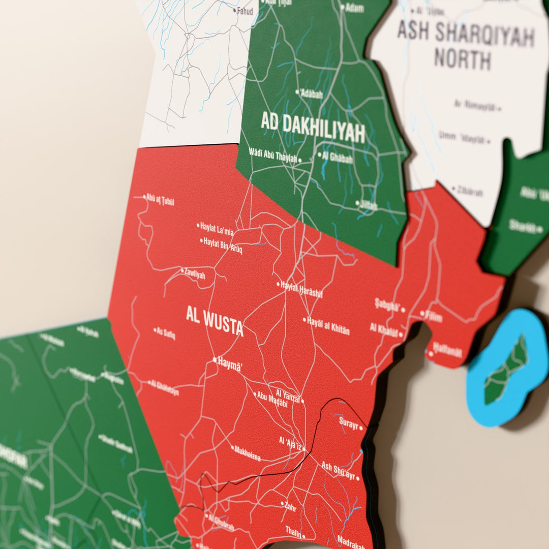 Close-up of the Flag colored Oman wooden wall map with layered regions and printed names