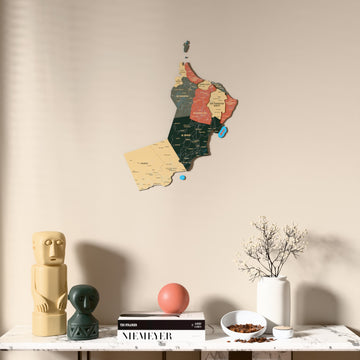 Sage Oman wooden wall map above a marble console, front view