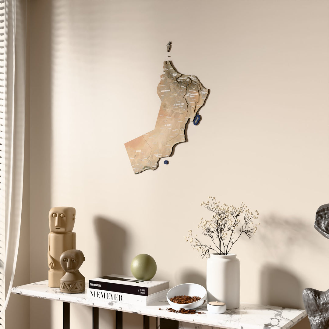 Satellite Oman wooden wall map beside a sheer curtain, angled view