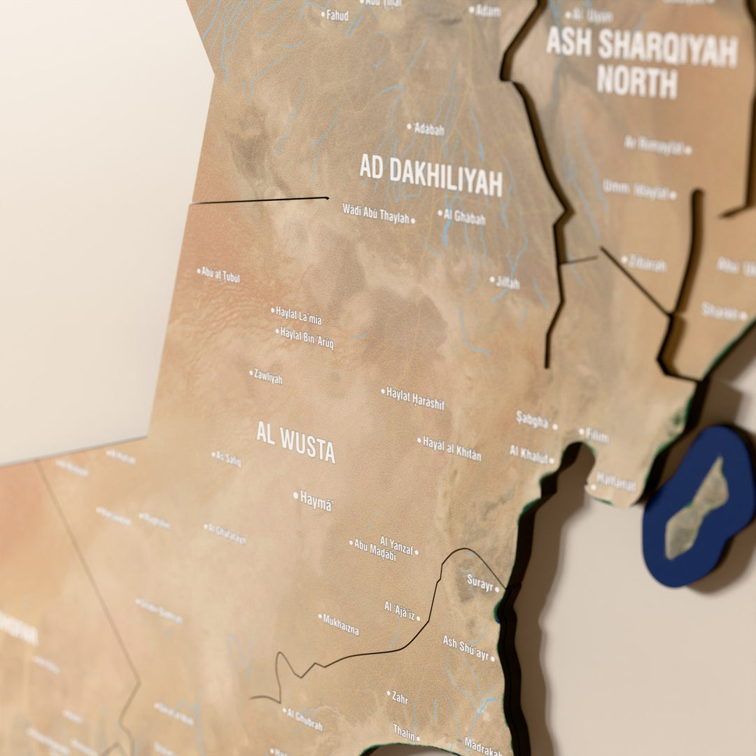 Close-up of the Satellite Oman wooden wall map with layered regions and printed names